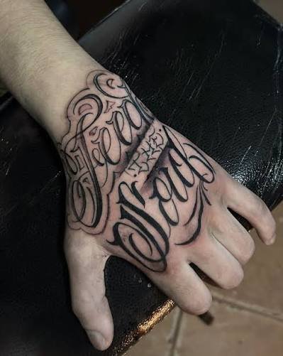 Tatuaje de Lettering con detalles ornamentales.